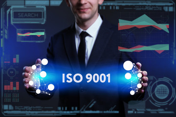 Business, Technology, Internet and network concept. Young businessman working on a virtual screen of the future and sees the inscription: ISO 9001