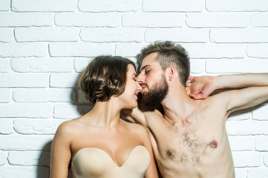 bearded slim man and pretty woman in bra kiss