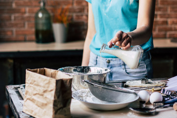 Obraz na płótnie Canvas Woman pouring milk into the bowl