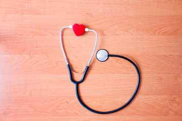 Medical diagnostic concept. Stethoscope with heart isolated on wooden background