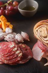 Meat and cheese sliced, sausage, bread. French traditional cuisine. Dark background,