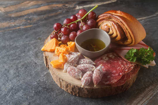 Meat and cheese sliced, sausage, bread. French traditional cuisine. Dark background,