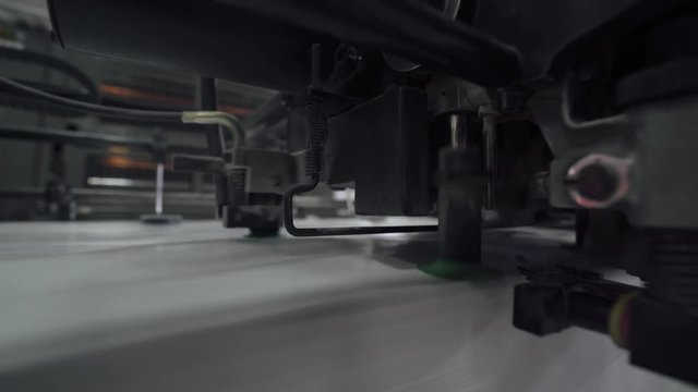 Offset printing press, industrial machine moving the paper material. Print house. Close-up. 4k footage.
