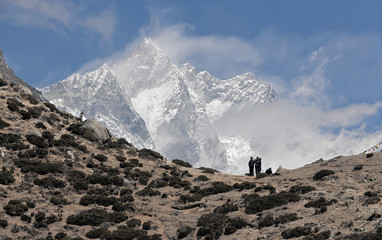 Trekkers in the Himalayas standing against peak Lhotse (8516 m) - Nepal, Himalayas