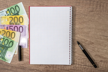 empty open notepad, pen, euro banknotes. Small business concept.