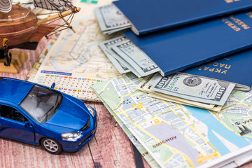 map with money, passport and toy car. time to travel.