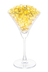 Fish oil soft capsule in cocktail glass with clipping path isolated on white background.