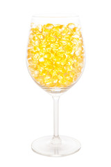 Fish oil soft capsule in wine glass with clipping path isolated on white background.