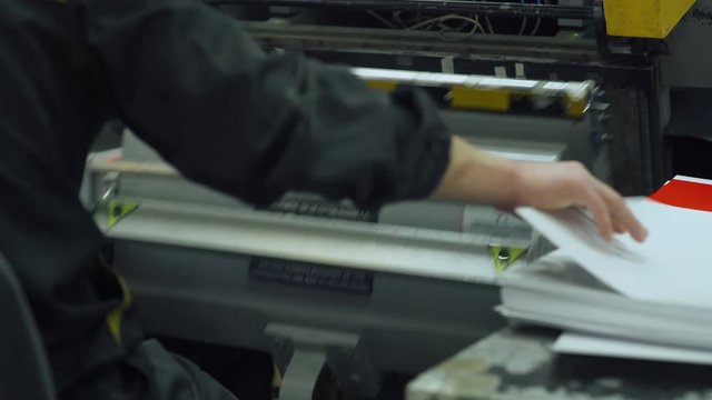Paper cutting, worker, printing production, industrial machine. Print house. 4k footage.
