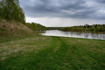 Fantastic river with fresh green grass in the sunlight.