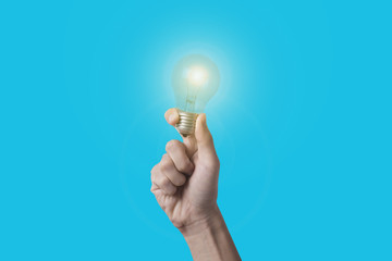 Business hand holding light bulb on blue background. concept of new ideas with innovation and creativity.