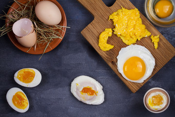 Different ways of cooking eggs: scrambled, omelette, boiled, raw and poached. Flat lay, top view with copy space