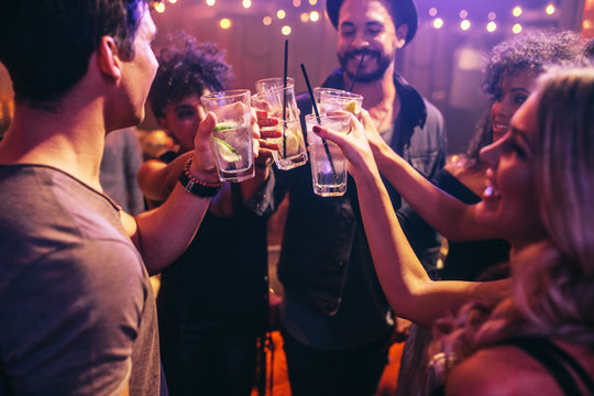 Friends at nightclub celebrating with drinks