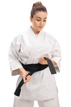 Karate girl tying a black belt