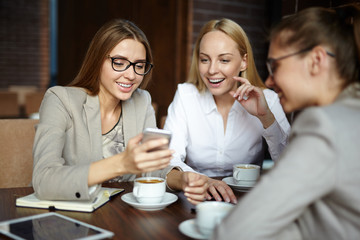 Group of young businesswomen reading data in gadget