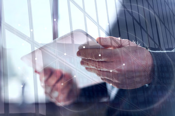 Businessman using his tablet, double exposure, overlayed with network