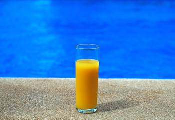 Orange juice near the pool. Space for text.