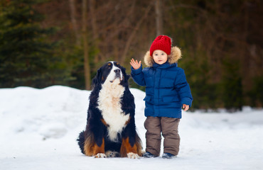 Naklejka na ściany i meble Little boy with big dog outdoor. Winter. .