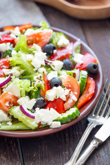 Greek Salad on Dark Wooden Background, Vertical Close Up View