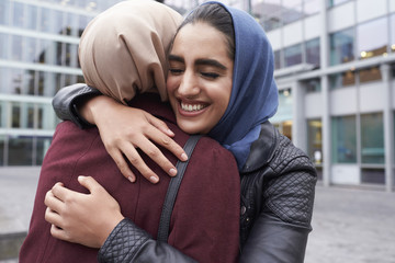 Two British Muslim Women Friends Meeting Outside Office
