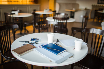 Table in cafe with drinks and business objects