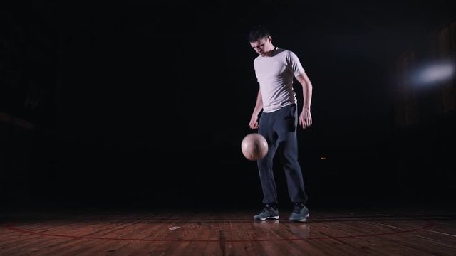 Young man doing freestyle football on a black background