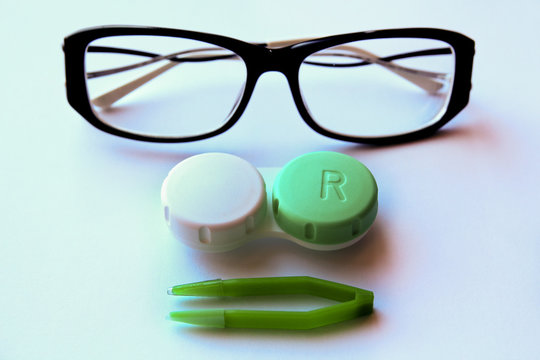 eyeglasses and eye contact lenses on white background.