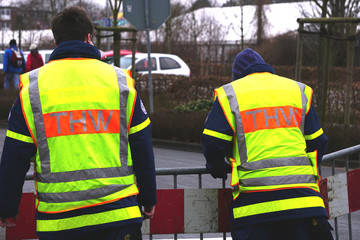 Zwei Mitarbeiter des THW im Einsatz auf der Straße.
