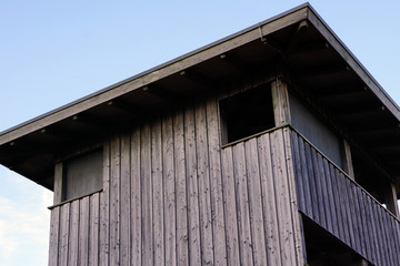 Ein Beobachtungsturm aus Holz. Ein Fenster ist geöffnet, eins geschlossen.