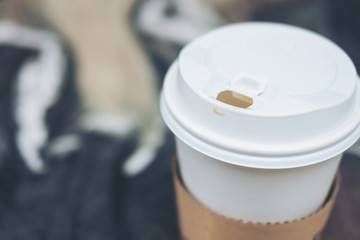 Closeup image of a paper cup of hot coffee on the table with blur background