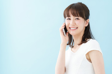 Fototapeta premium スマートフォン・女性・ブルーバック