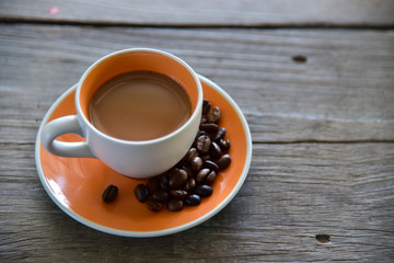 Fototapeta premium A Cup coffee and beans on wooden 