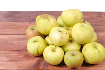 pile of green apples lying on a wooden background