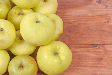 Fresh green apples on a wooden surface