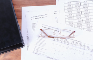The table with its glasses, financial papers and a closed laptop