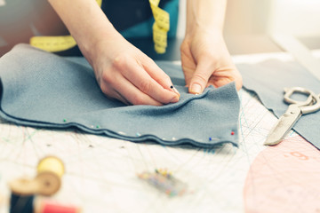 tailor marking the fabric with sewing pins