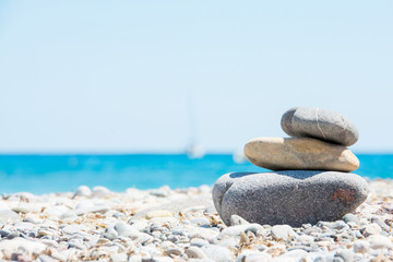 Fototapeta na wymiar Relaxing in summer concept. Stones on the beach with boat on background.