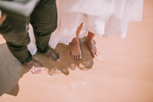bride groom barefoot on the beach