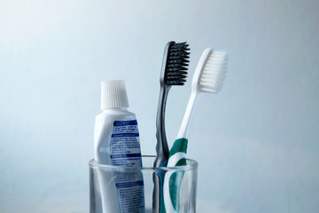 Black and white Toothbrush and toothpaste in glass