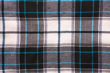 White-black textile texture of the checkered shirt useful as background