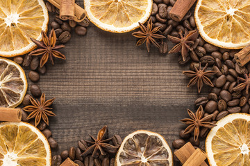grapefruit and orange slices with coffee beans and spices on wooden background