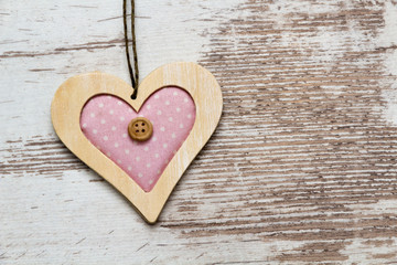 big pink colored wooden heart on white wooden wall