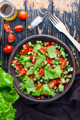 Fresh vegetable salad in a clay bowl, top view