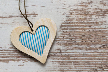 blue colored wooden heart on white wooden wall