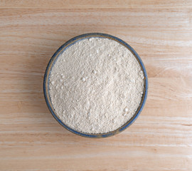 Top view of quinoa flour in a large bowl on a wood table.