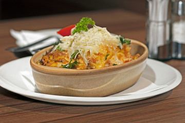 Lasagne with ruccola in wooden dish