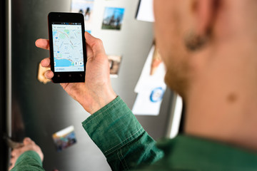 Person hands holding smartphone and searching for places to eat on map