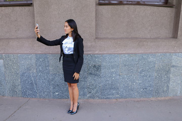 Charming cute girl photographed, makes selfie photos and smiling