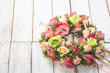 Fototapeta na wymiar Wedding wreath with roses on white wooden background
