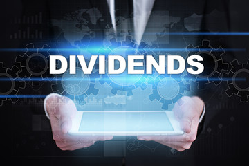Businessman holding tablet PC with dividends concept.